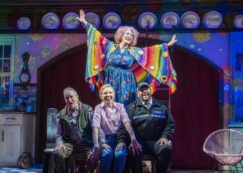Dame Maureen Lipman as Allegra stands above John Middleton as Ronen, Elizabeth Bower as Anna and Bailey Patrick as Officer Rogers during a colourful musical number.